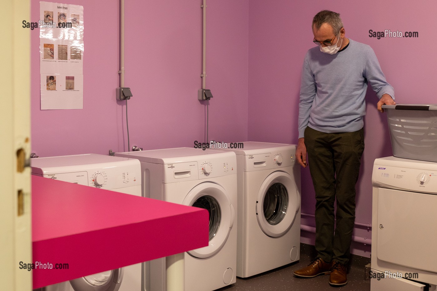 RESIDENT DANS LA BUANDERIE POUR LAVER SON LINGE, FOYER D'HEBERGEMENT POUR ADULTES EN SITUATION DE HANDICAP INTELLECTUEL, RESIDENCE LA CHARENTONNE, ADAPEI27, ASSOCIATION DEPARTEMENTALE D'AMIS ET DE PARENTS, BERNAY, EURE, NORMANDIE, FRANCE 