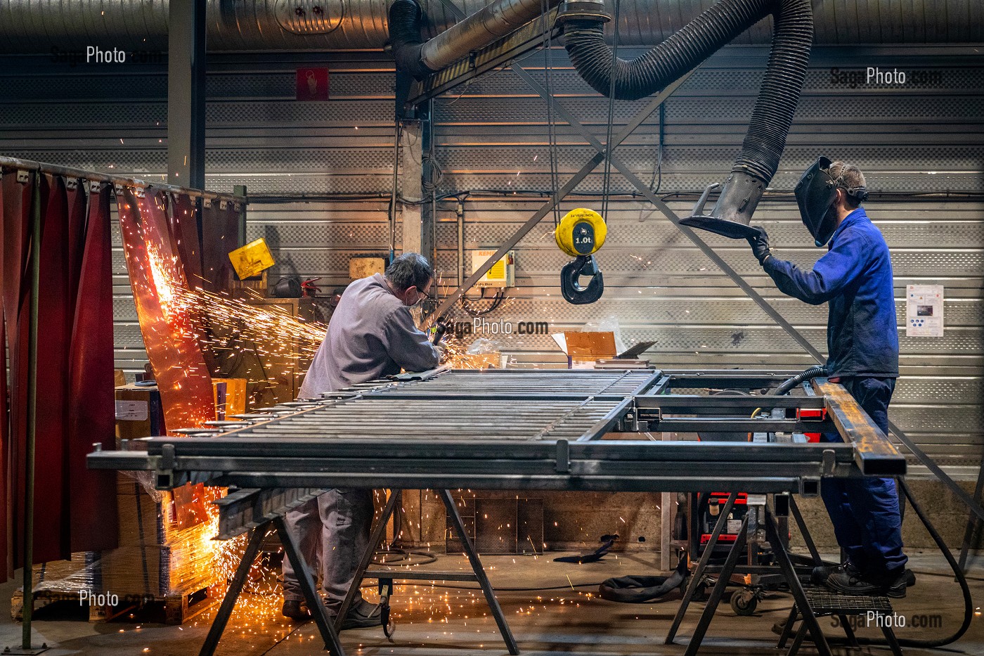 POSTE DE SOUDURE, OUVRIER SOUDEUR AU TRAVAIL POUR MEULAGE DE PIECES METALLIQUES DANS SON USINE, L'AIGLE, ORNE, NORMANDIE, FRANCE 