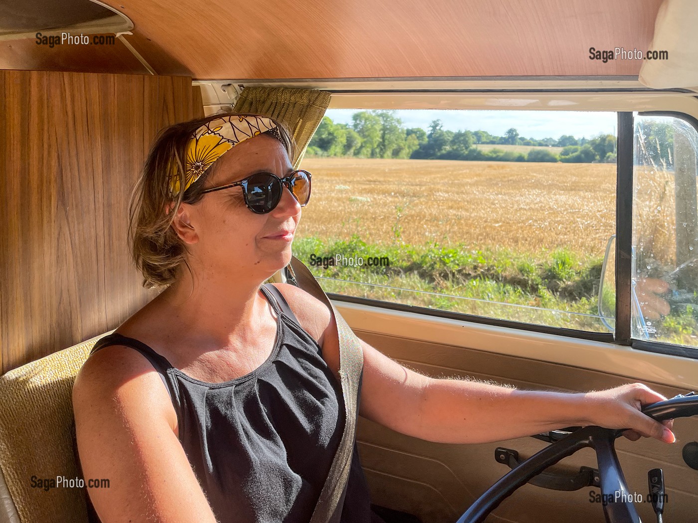 FEMME AU VOLANT LORS D'UNE BALADE EN CAMPAGNE A BORD D'UN COMBI VOLKSWAGEN, MANCHE, NORMANDIE, FRANCE 