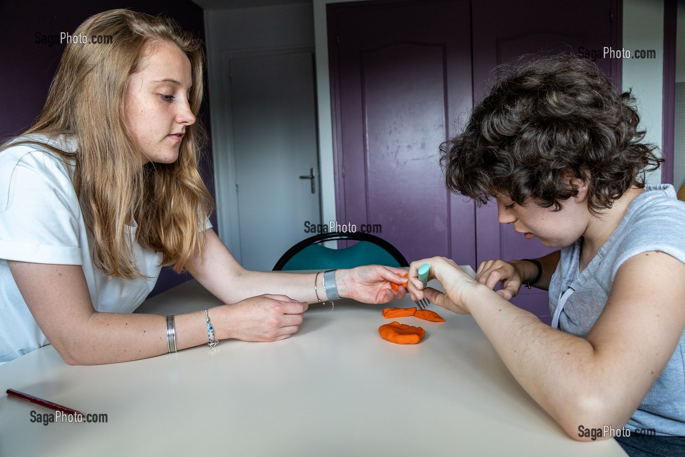 SEANCE D'ERGOTHERAPIE AVEC UN RESIDENT POUR APPRENDRE A TENIR SES COUVERTS A TABLE, SESSAD LA RENCONTRE, ACCUEIL DE JOUR, ORGANISME DE SOUTIEN ET DE SERVICES AUX PERSONNES HANDICAPEES, LE NEUBOURG, EURE, NORMANDIE, FRANCE 