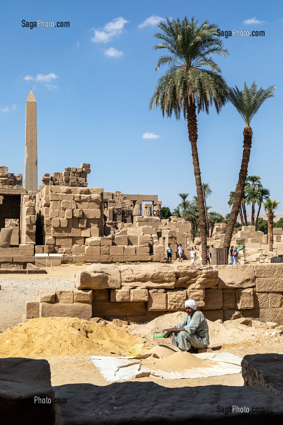 HOMME QUI TRAVAILLE A TAMISER LE SABLE EN PLEIN SOLEIL, RUINES ET OBELISQUE, DOMAINE D'AMON, TEMPLE DE KARNAK, SITE DE L'EGYPTE ANTIQUE DE LA XIII EME DYNASTIE, PATRIMOINE MONDIAL DE L'UNESCO, LOUXOR, EGYPTE, AFRIQUE 