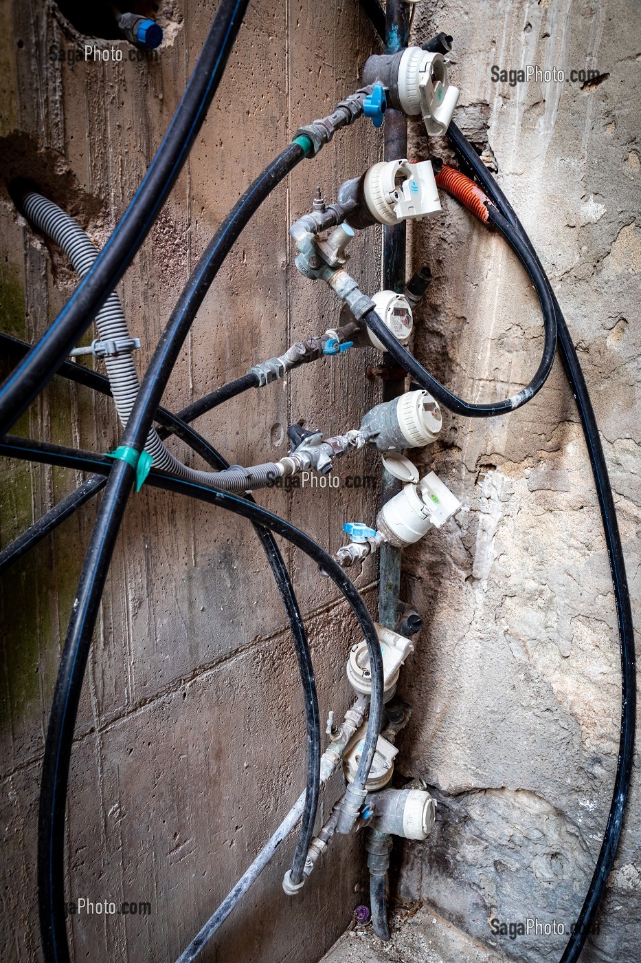 RANGEE DE COMPTEURS D'EAU ET TUYAUX SUR UN MUR EN BETON A BASTIA
