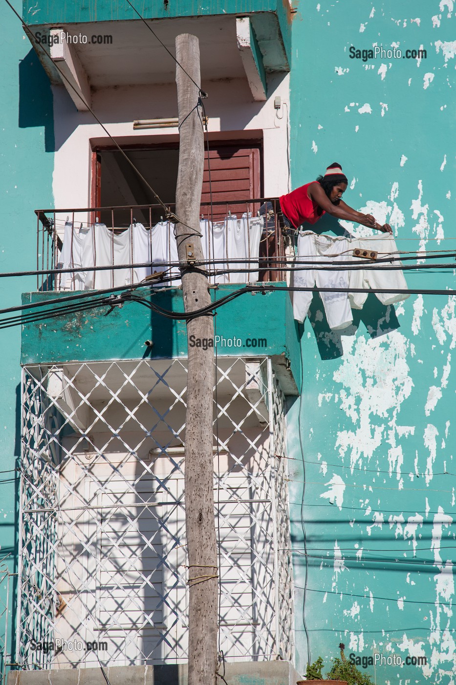 FEMME CUBAINE ETENDANT SON LINGE SUR UNE FACADE COLOREE DECREPIE, TRINIDAD, CLASSEE AU PATRIMOINE MONDIAL DE L’HUMANITE PAR L’UNESCO, CUBA, CARAIBES 