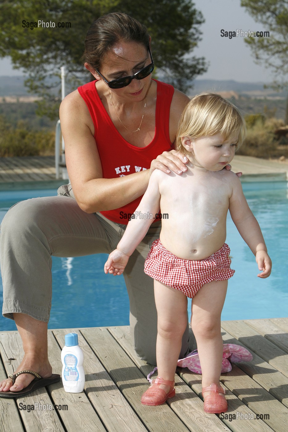 MERE ETALE DE LA CREME SOLAIRE POUR PROTEGER LA PEAU DE SON ENFANT DES RAYONS DU SOLEIL 