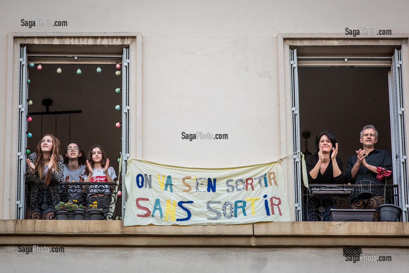 BANDEROLE 'ON VA S'EN SORTIR SANS SORTIR', ISABELLE, INFIRMIERE, OLIVIER ET LEURS TROIS FILLES SOUTIENNENT LES SOIGNANTS A 20H TOUS LES SOIRS ILS APPLAUDISSENT LES SOIGNANTS LORS DU CONFINEMENT DE LA PANDEMIE DU COVID 19, CHARENTON LE PONT, ILE DE FRANCE 