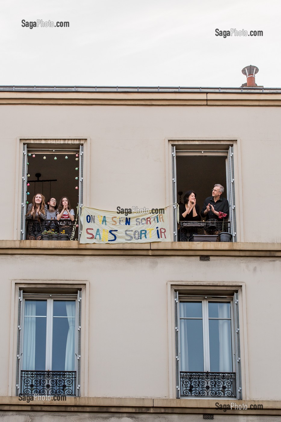 BANDEROLE 'ON VA S'EN SORTIR SANS SORTIR', ISABELLE, INFIRMIERE, OLIVIER ET LEURS TROIS FILLES SOUTIENNENT LES SOIGNANTS A 20H TOUS LES SOIRS ILS APPLAUDISSENT LES SOIGNANTS LORS DU CONFINEMENT DE LA PANDEMIE DU COVID 19, CHARENTON LE PONT, ILE DE FRANCE 