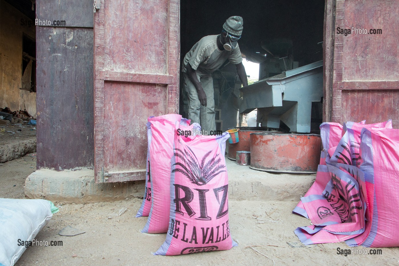 OUVRIER DANS LE BRUIT ET LA POUSSIERE, UNITE DE TRANSFORMATION DE RIZ DE QUALITE, DAGANA, SENEGAL, AFRIQUE DE L'OUEST 