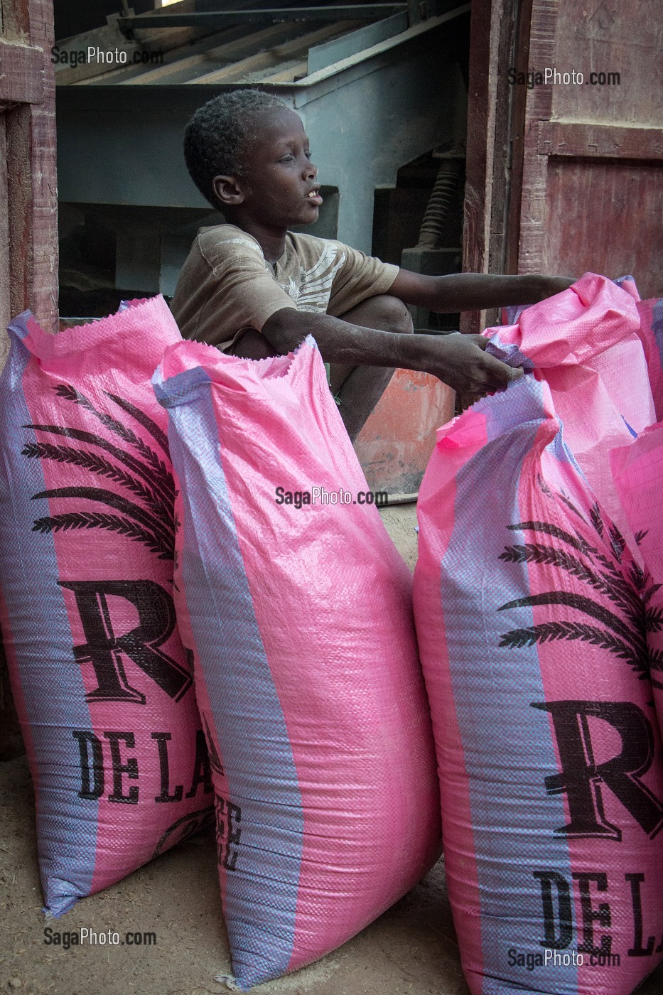 ENFANT A LA PREPARATION DES SACS DE RIZ, UNITE DE TRANSFORMATION DE RIZ DE QUALITE, DAGANA, SENEGAL, AFRIQUE DE L'OUEST 