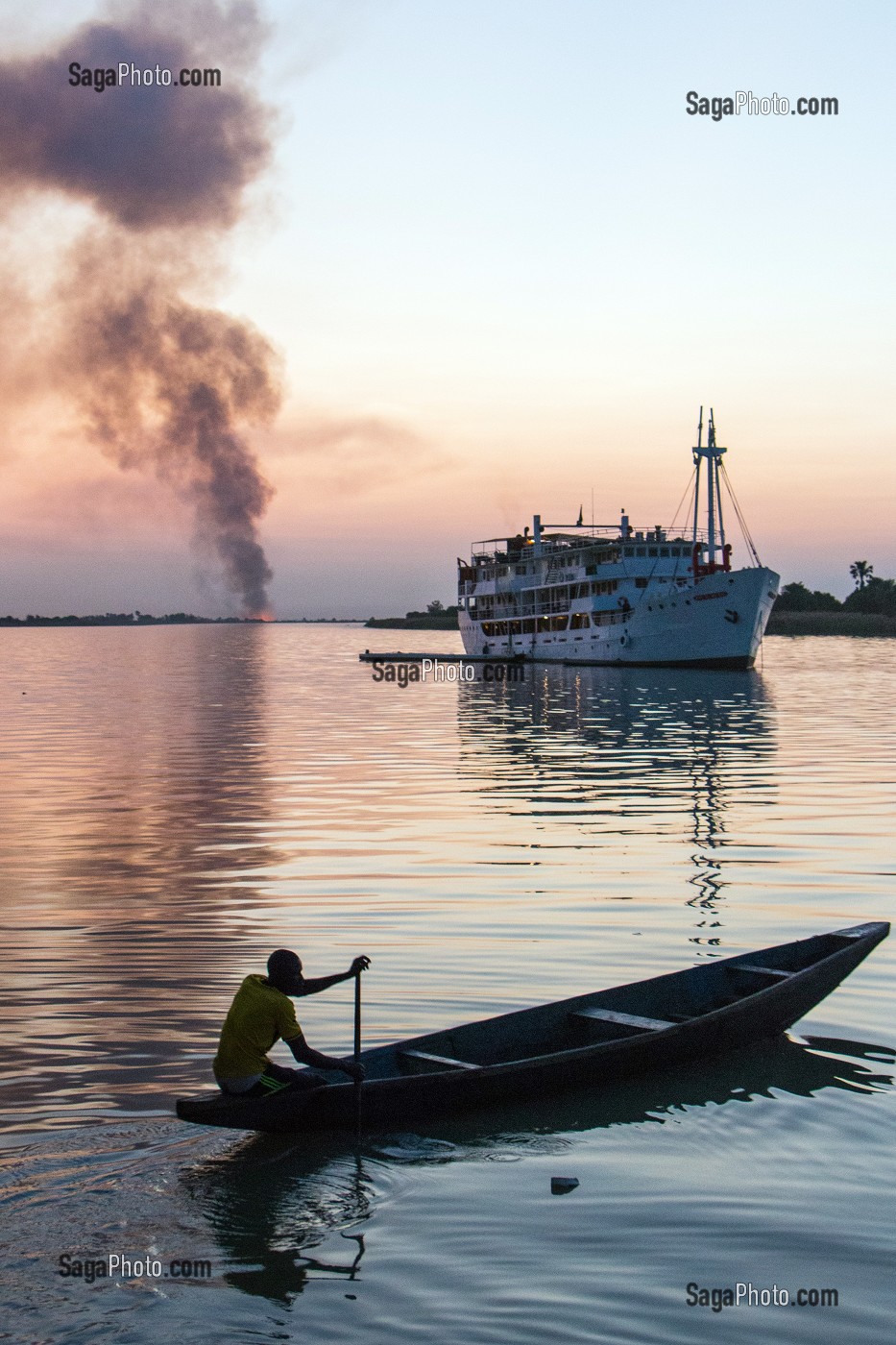 TRAVERSEE DE PIROGUES DEPUIS LA MAURITANIE SUR LE FLEUVE AVEC LES FEUX DE CANNE A SUCRE AU COUCHER DE SOLEIL ET LE BATEAU DE CROISIERE 'BOU EL MOGDAD' DE LA COMPAGNIE DU FLEUVE, , DAGANA, SENEGAL, AFRIQUE DE L'OUEST 