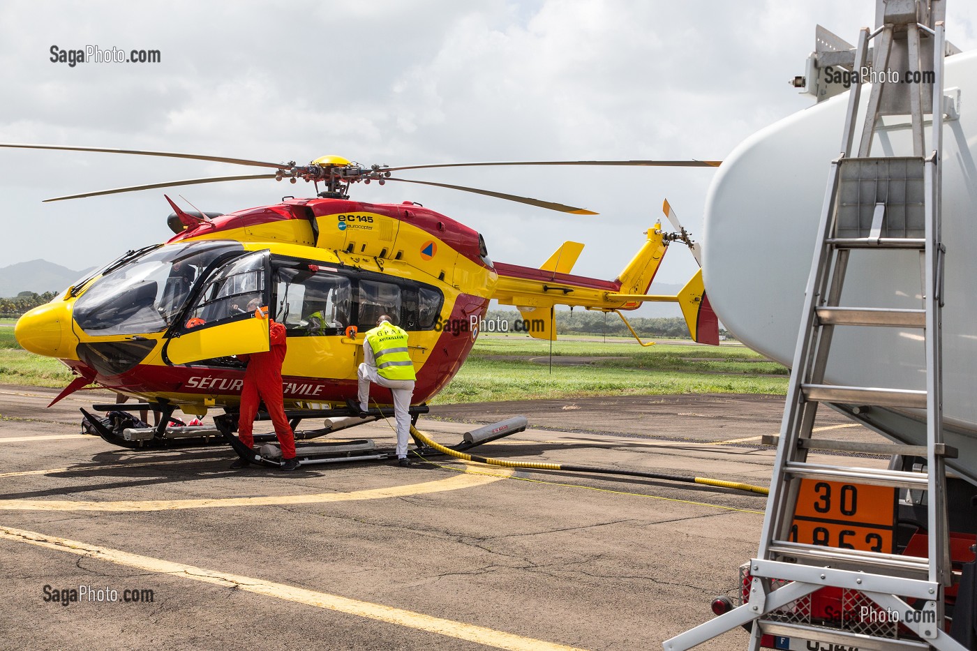 RAVITAILLEUR EN TRAIN DE FAIRE LE PLEIN DE CARBURANT DE L'EC145 AVEC SON CAMION CITERNE, SECOURS HELIPORTES AVEC L'HELICOPTERE DRAGON 972 DE LA SECURITE CIVILE, MARTINIQUE, FRANCE 