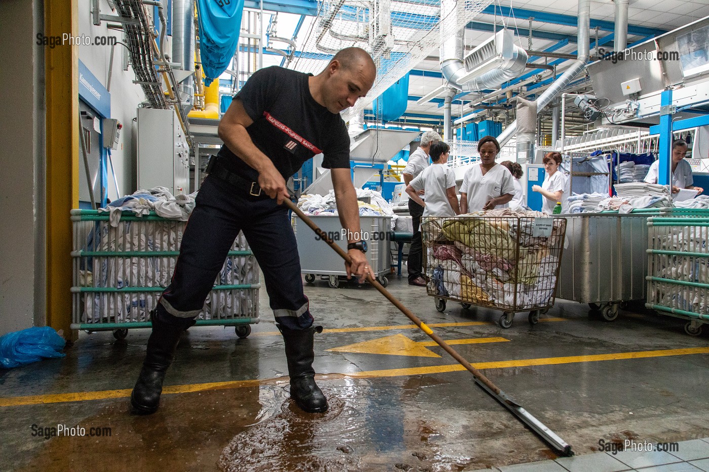 SAPEUR-POMPIER PASSANT LA RACLETTE APRES UNE INONDATION DANS UNE BLANCHISSERIE INDUSTRIELLE, CENTRE DE SECOURS PRINCIPAL DE CHAMBERY, SAVOIE (73), FRANCE 