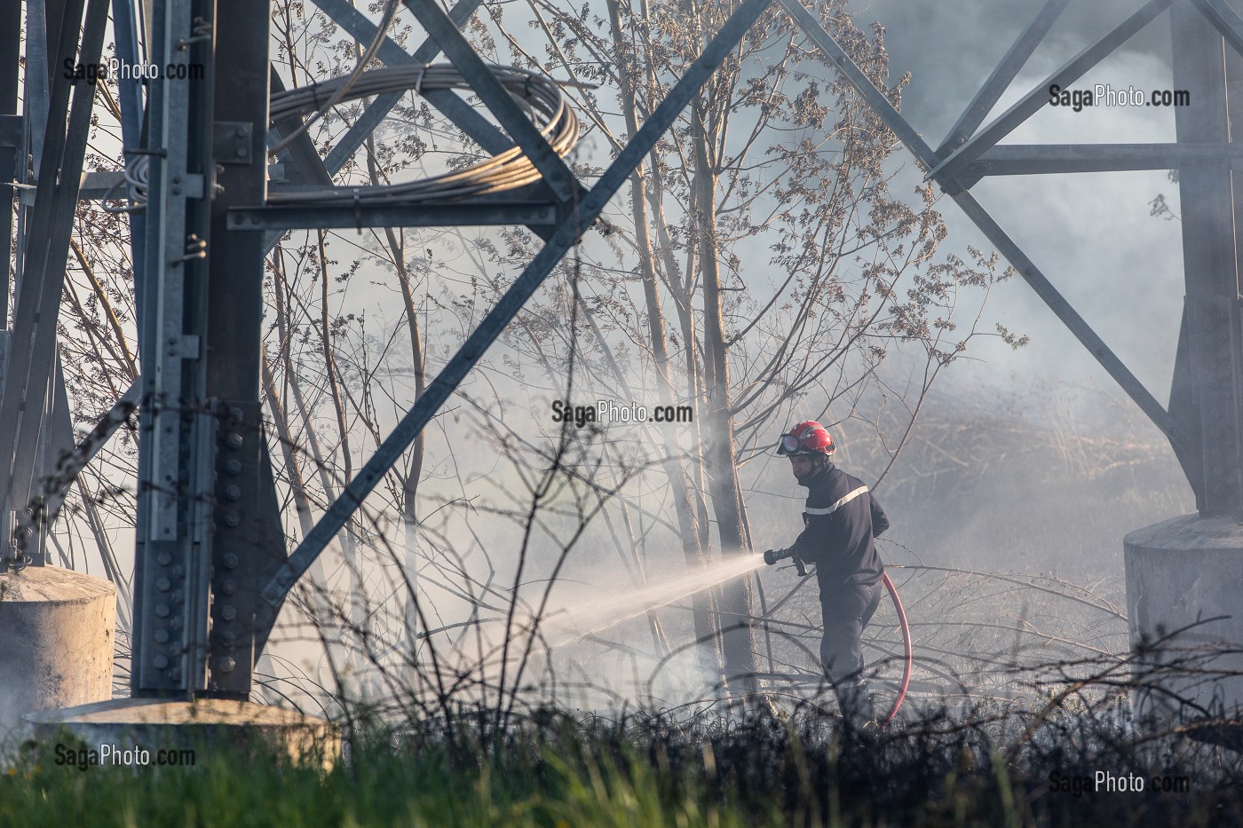 SAPEUR-POMPIER EN TRAIN D'ETEINDRE UN FEU DE BROUSSAILLES SOUS DES PYLONES DE LIGNES A HAUTE TENSION, SAPEURS-POMPIERS PRINCIPAL DU CENTRE DE SECOURS DE CHAMBERY, LES MARCHES, SAVOIE (73), FRANCE 