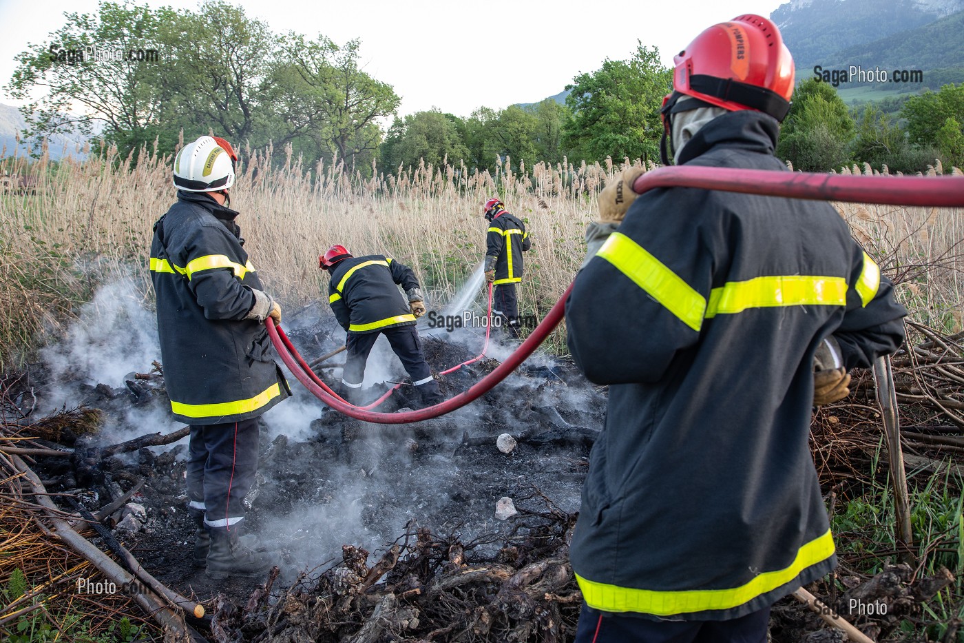 SAPEURS-POMPIERS EN TRAIN D'ETEINDRE UN FEU DE BROUSSAILLES (ROSEAUX) AVEC DES BATTES A FEU ET UNE PETITE LANCE, PRINCIPAL DU CENTRE DE SECOURS DE CHAMBERY, LES MARCHES, SAVOIE (73), FRANCE 