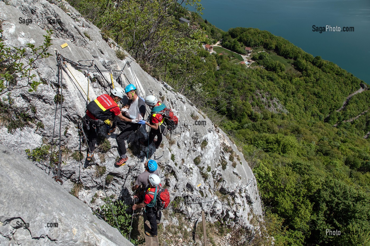 POSE D'UNE ATTELLE, INTERVENTION DE L'EQUIPE DE SECOURS EN MONTAGNE POUR UNE CHUTE AVEC ENTORSE AU BRAS SUR LA VIA FERRATA DU ROCHER DU CORNILLON AU DESSUS DU LAC DU BOURGET, LA CHAPELLE DU MONT-DU-CHAT (73), FRANCE 