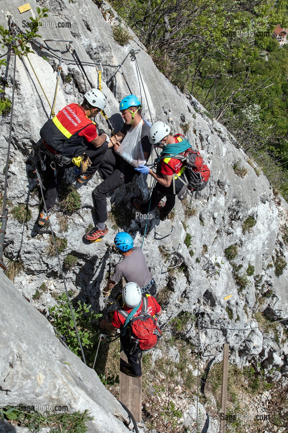 POSE D'UNE ATTELLE, INTERVENTION DE L'EQUIPE DE SECOURS EN MONTAGNE POUR UNE CHUTE AVEC ENTORSE AU BRAS SUR LA VIA FERRATA DU ROCHER DU CORNILLON AU DESSUS DU LAC DU BOURGET, LA CHAPELLE DU MONT-DU-CHAT (73), FRANCE 