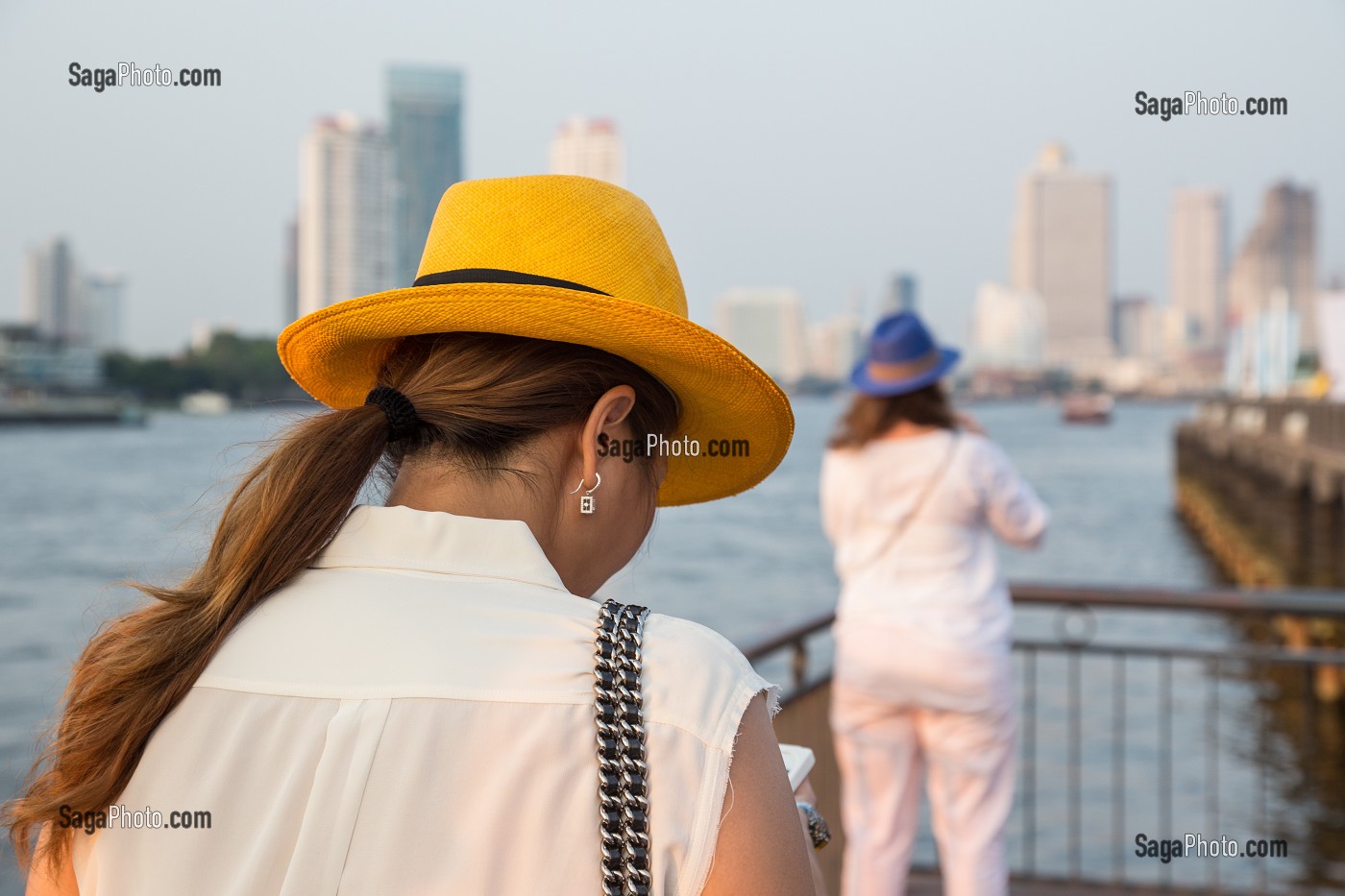JEUNE FEMME AU CHAPEAU JAUNE, BALADE TOURISTIQUE SUR LA PROMENADE DE L'ASIATIQUE THE RIVERFRONT PRES DE LA RIVIERE CHAO PHRAYA, BANGKOK, THAILANDE, ASIE 