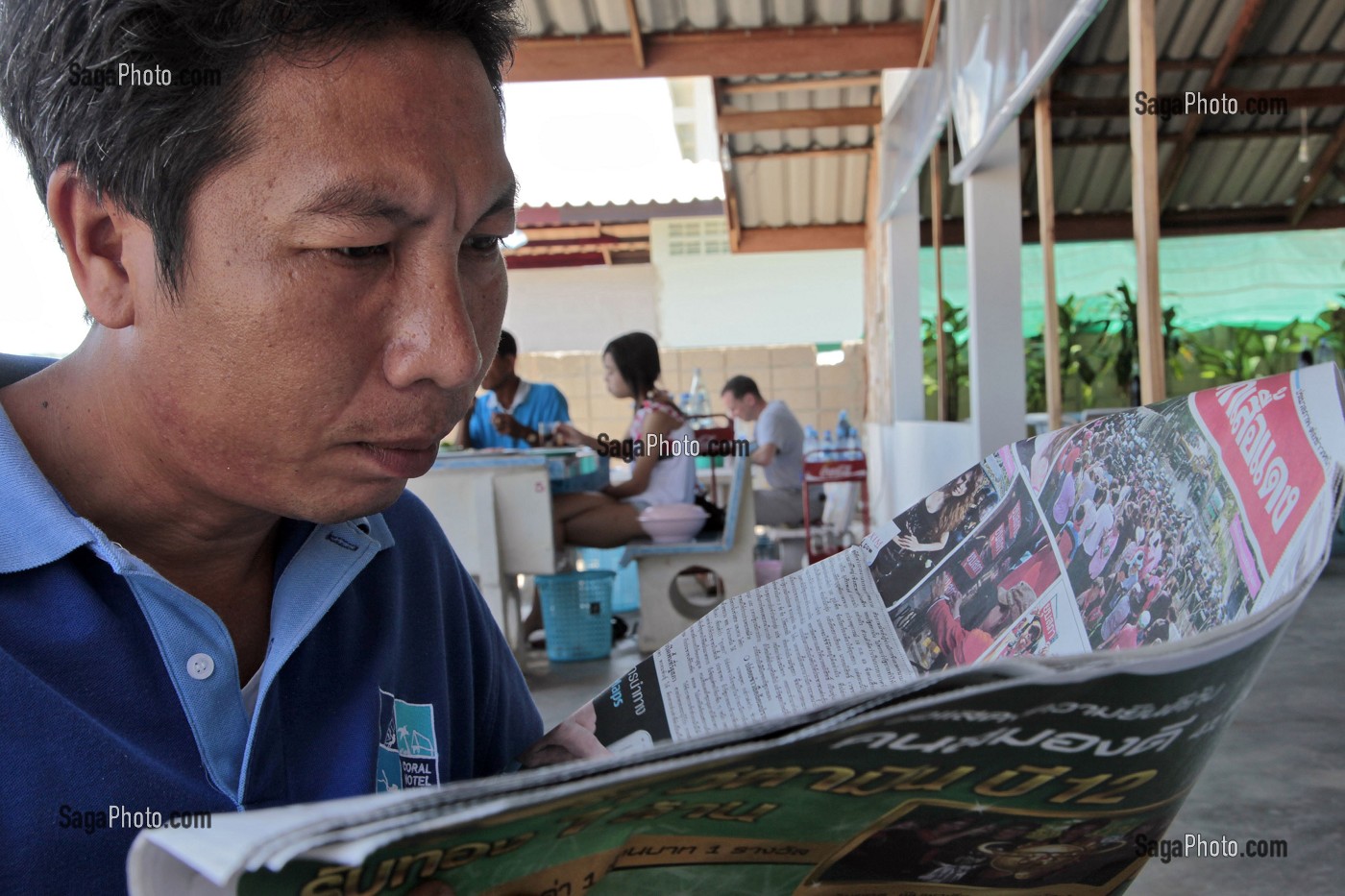 HOMME LISANT SON JOURNAL, CHUMPHON, THAILANDE 