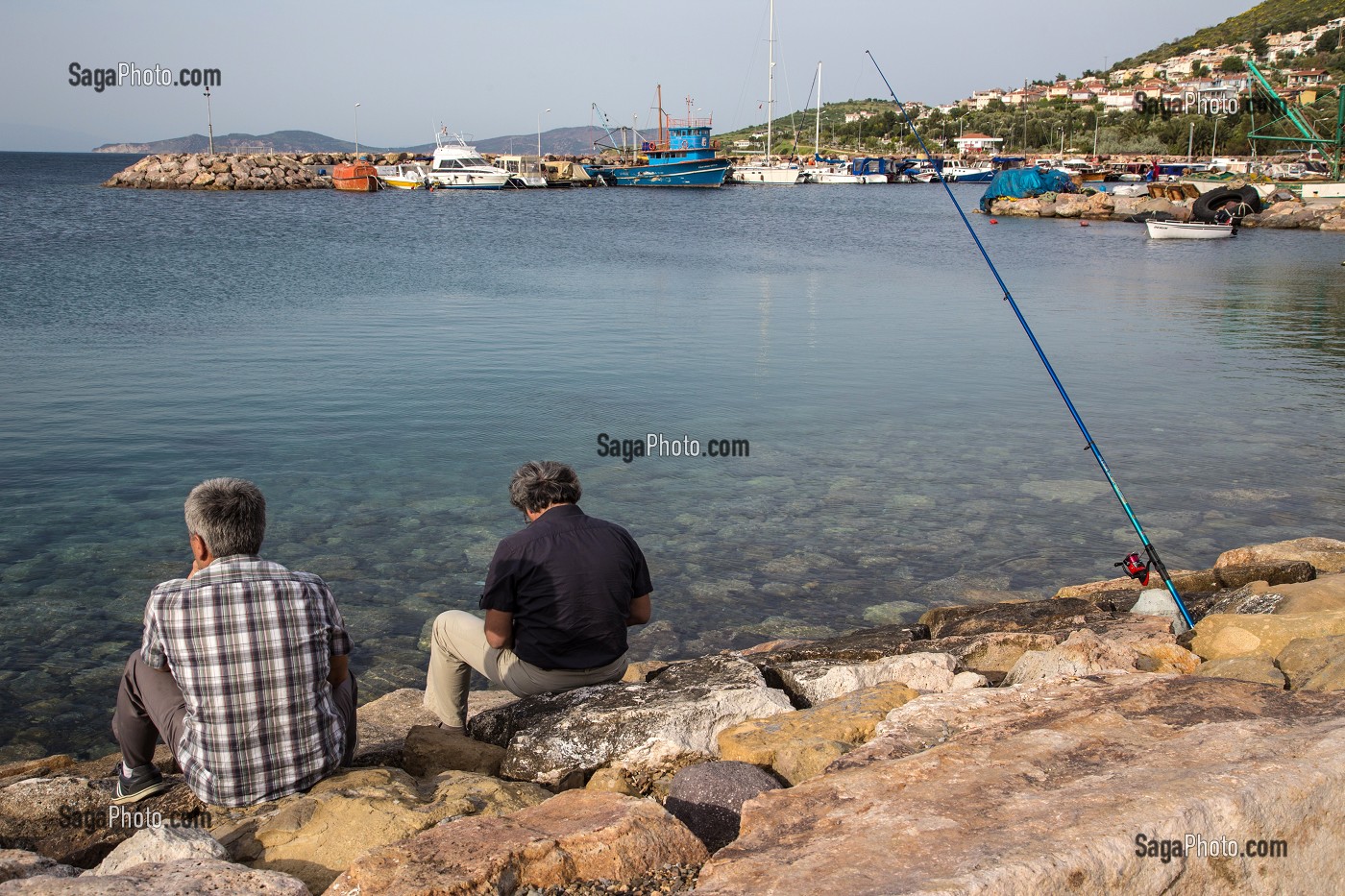 HOMMES A LA PECHE EN FACE DU PORT DE PECHEURS DU VILLAGE DE YENIFOCA, RIVIERA DES OLIVIERS SUR LES BORDS DE LA MER EGEE, NORD D'IZMIR, TURQUIE 