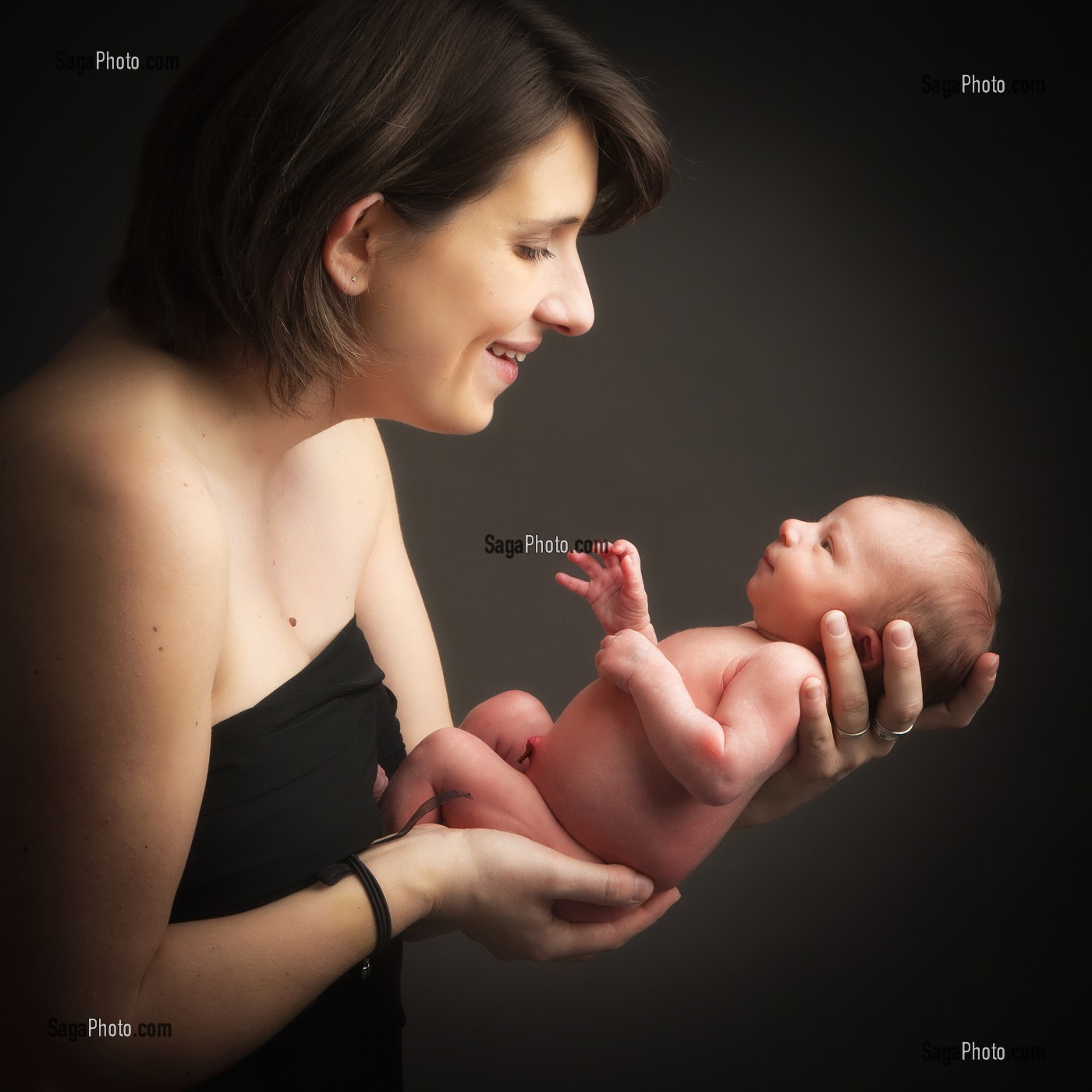 MAMAN ET SON BEBE NOUVEAU-NE DANS SES MAINS, PORTRAIT EN STUDIO 
