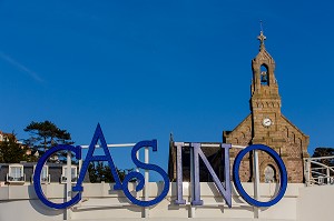 ENSEIGNE DU CASINO ET EGLISE SAINT-PIERRE-SAINT-PAUL EN ARRIERE-PLAN, PLENEUF-VAL-ANDRE, (22) COTES-D’ARMOR, BRETAGNE, FRANCE 