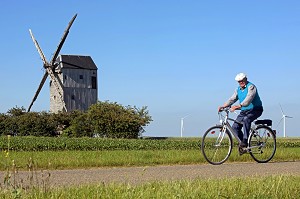 HOMME A VELO DEVANT LES EOLIENNES ET LE MOULIN A VENT DE LEVESVILLE LA CHENARD, PARC EOLIEN DE LA BEAUCE, EURE-ET-LOIR (28), FRANCE 