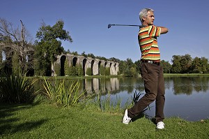 JOUEUR DE GOLF DEVANT L'AQUEDUC DE MAINTENON, EURE-ET-LOIR (28), FRANCE 