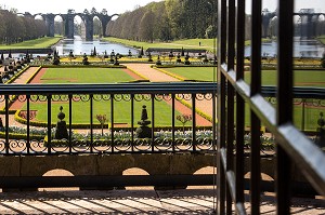 FENETRE AVEC VUE SUR LE JARDIN A LA FRANCAISE REALISE SUIVANT LES PLANS DU JARDINIER DU ROI LOUIS XIV, ANDRE LE NOTRE AVEC L'AQUEDUC VAUBAN AU FOND DU PARC, CHATEAU DE MAINTENON, FRANCE 