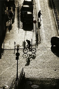 PIETON ET CYCLISTE DANS LA RUE, SCENE DE RUE A CONTRE-JOUR APRES L'AVERSE, VILLE DE TOULOUSE, HAUTE-GARONNE (31), FRANCE 