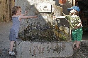 ENFANTS JOUANT AVEC L'EAU D'UNE FONTAINE, SAINT GUILHEM LE DESERT (34), VILLAGE MEDIEVAL, ETAPE DU PELERINAGE DE SAINT JACQUES DE COMPOSTELLE, LABELISE PLUS BEAU VILLAGE DE FRANCE  