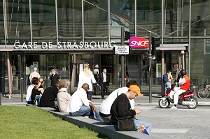 PASSANT ASSIS DEVANT LA VERRIERE DE LA GARE DE STRASBOURG, STRASBOURG, FRANCE, EUROPE 