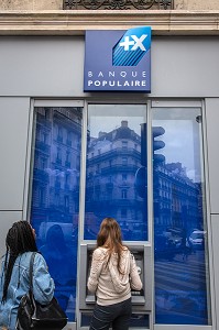 JEUNES FEMMES DEVANT UN DISTRIBUTEUR DE BILLETS DE LA BANQUE POPULAIRE, RUE DE RENNES, 6EME ARRONDISSEMENT, PARIS, FRANCE 