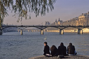 ADOLESCENTS ASSIS A LA POINTE DU SQUARE DU VERT GALANT EN BORD DE SEINE, PONT DES ARTS EN ARRIERE-PLAN. PONT DES ARTS, PARIS, PARIS (75), FRANCE 