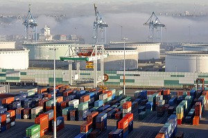ZONE DE STOCKAGE DES CONTENEURS ET CUVES DE PETROLE SUR LE TERMINAL DE FRANCE, PORT 2000, PORTIQUE DE CHARGEMENT DANS LA BRUME DU MATIN, PORT DE COMMERCE, LE HAVRE, NORMANDIE 