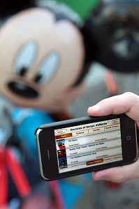 VISITEUR VERIFIANT SUR SON TELEPHONE PORTABLE LES TEMPS D'ATTENTE AUX ATTRACTIONS, GESTION DES FLUX DE VISITEURS, PARC D'ATTRACTIONS DISNEYLAND PARIS (EURODISNEY), MARNE-LA-VALLEE, SEINE-ET-MARNE (77), ILE-DE-FRANCE, FRANCE 