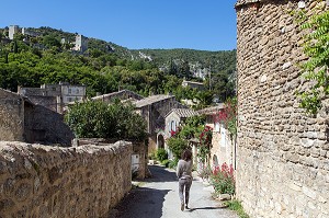 FEMME DANS UNE RUELLE DU VILLAGE ET CHATEAU D'OPPEDE-LE-VIEUX, PARC NATUREL REGIONAL DU LUBERON, VAUCLUSE (84), FRANCE 