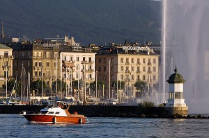 BATEAU DEVANT LE PETIT PHARE ET LE JET D'EAU SYMBOLE DE LA VILLE DANS LA RADE DE GENEVE, SUISSE SUR LE LAC LEMAN 