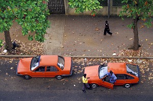 CHAUFFEUR DE TAXIS ET AGENT DE POLICE REGARDANT PASSER UNE JEUNE FEMME ABIDJAN, COTE D'IVOIRE 