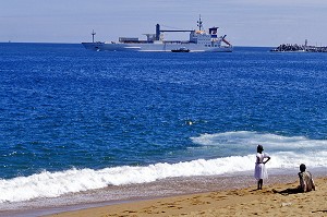 ENFANTS SUR LA PLAGE DEVANT UN NAVIRE DE COMMERCE, ABIDJAN, COTE D'IVOIRE 