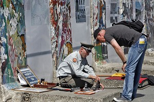 HOMME HABILLE EN MILITAIRE DE L'EX RDA PROPOSE AUX TOURISTES DES TAMPON DE VISA DE LA RDA DEVANT DES FRAGMENTS DU MUR DE BERLIN DE L'EX RDA, BERLIN MAUER, POTSDAMER PLATZ, BERLIN, ALLEMAGNE 