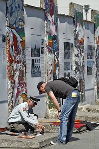 HOMME HABILLE EN MILITAIRE DE L'EX RDA PROPOSE AUX TOURISTES DES TAMPON DE VISA DE LA RDA DEVANT DES FRAGMENTS DU MUR DE BERLIN DE L'EX RDA, BERLIN MAUER, POTSDAMER PLATZ, BERLIN, ALLEMAGNE 