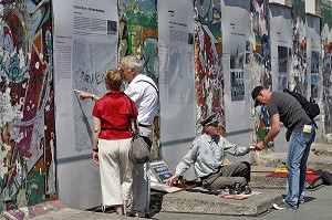 HOMME HABILLE EN MILITAIRE DE L'EX RDA PROPOSE AUX TOURISTES DES TAMPON DE VISA DE LA RDA DEVANT DES FRAGMENTS DU MUR DE BERLIN DE L'EX RDA, BERLIN MAUER, POTSDAMER PLATZ, BERLIN, ALLEMAGNE 