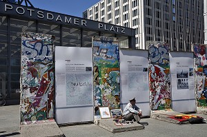 HOMME HABILLE EN MILITAIRE DE L'EX RDA PROPOSE AUX TOURISTES DES TAMPON DE VISA DE LA RDA DEVANT DES FRAGMENTS DU MUR DE BERLIN DE L'EX RDA, BERLIN MAUER, POTSDAMER PLATZ, BERLIN, ALLEMAGNE 
