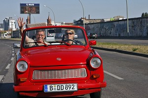 COUPLE VISITANT BERLIN EN TRABANT,  LA VOITURE FAMILIALE DE L'EX RDA DEVENUE CULTE SYMBOLE DE L'ALLEMAGNE DE L'EST, TRABI SAFARI ET EAST SIDE GALLERY, BERLIN, ALLEMAGNE 