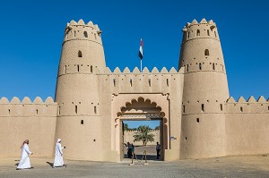 EMIRATIS EN TENUE TRADITIONNELLE SE DIRIGEANT VERS L'ENTREE DU FORT D'AL JAHILI, AL AIN, EMIRAT D'ABOU DABI, EMIRAT D'ABU DHABI, GOLFE PERSIQUE, EAU, EMIRATS ARABES UNIS 