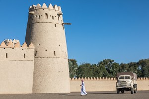 EMIRATI EN TENUE TRADITIONNELLE SE PROMENANT DANS L'ENCEINTE DU FORT D'AL JAHILI, VIEUX CAMION DE L'EPOQUE COLONIALE BRITANNIQUE, AL AIN, EMIRAT D'ABOU DABI, EMIRAT D'ABU DHABI, GOLFE PERSIQUE, EAU, EMIRATS ARABES UNIS 