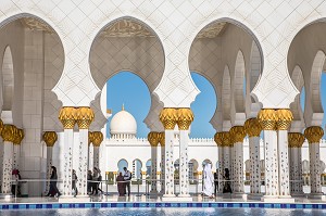 TOURISTES INTERNATIONAUX ET VISITEUR EMIRATI EN TENUE TRADITIONNELLE DANS LES ALLEES DE LA MOSQUEE SHEIKH ZAYED D'ABU DHABI, RELIGION, TRADITION, ISLAM, MUSULMANS, TOURISME CULTUREL, ABU DHABI, ABOU DABI, GOLFE PERSIQUE, EAU, EMIRATS ARABES UNIS 