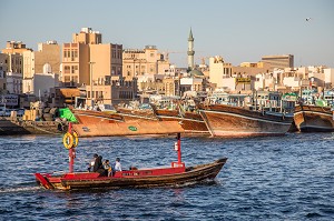 BARQUE A MOTEUR APPELE ABRA NAVIGANT DANS LA CRIQUE DE DUBAI AVEC DES BOUTRES ET LE QUARTIER DE DEIRA, MOSQUEE AVEC UN MINARET, DUBAI, GOLFE PERSIQUE, EAU, EMIRATS ARABES UNIS 