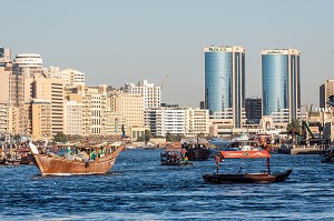 TRAFIC MARITIME AVEC BATEAUX DE COMMERCE ET ABRAS DANS LA CRIQUE DE DUBAI AVEC LES TOURS JUMELLES DE DEIRA EN FOND, DUBAI, GOLFE PERSIQUE, EAU, EMIRATS ARABES UNIS 