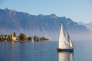 BATEAU VOGUANT SUR LE LAC LEMAN AVEC LE CHATEAU ABRITANT LE MUSEE SUISSE DU JEU ET LES ALPES SUISSES EN FOND, VEVEY, CANTON DE VAUD, SUISSE 
