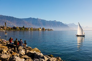 BATEAU VOGUANT SUR LE LAC LEMAN AVEC DES PROMENEURS ET LA FOURCHETTE DE VEVEY, SCULPTURE REALISE PAR L'ARTISTE SUISSE  JEAN-PIERRE ZAUGG, LAC LEMAN, VEVEY, CANTON DE VAUD, SUISSE 